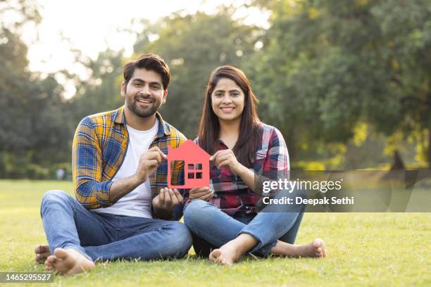 young couple holding a house model